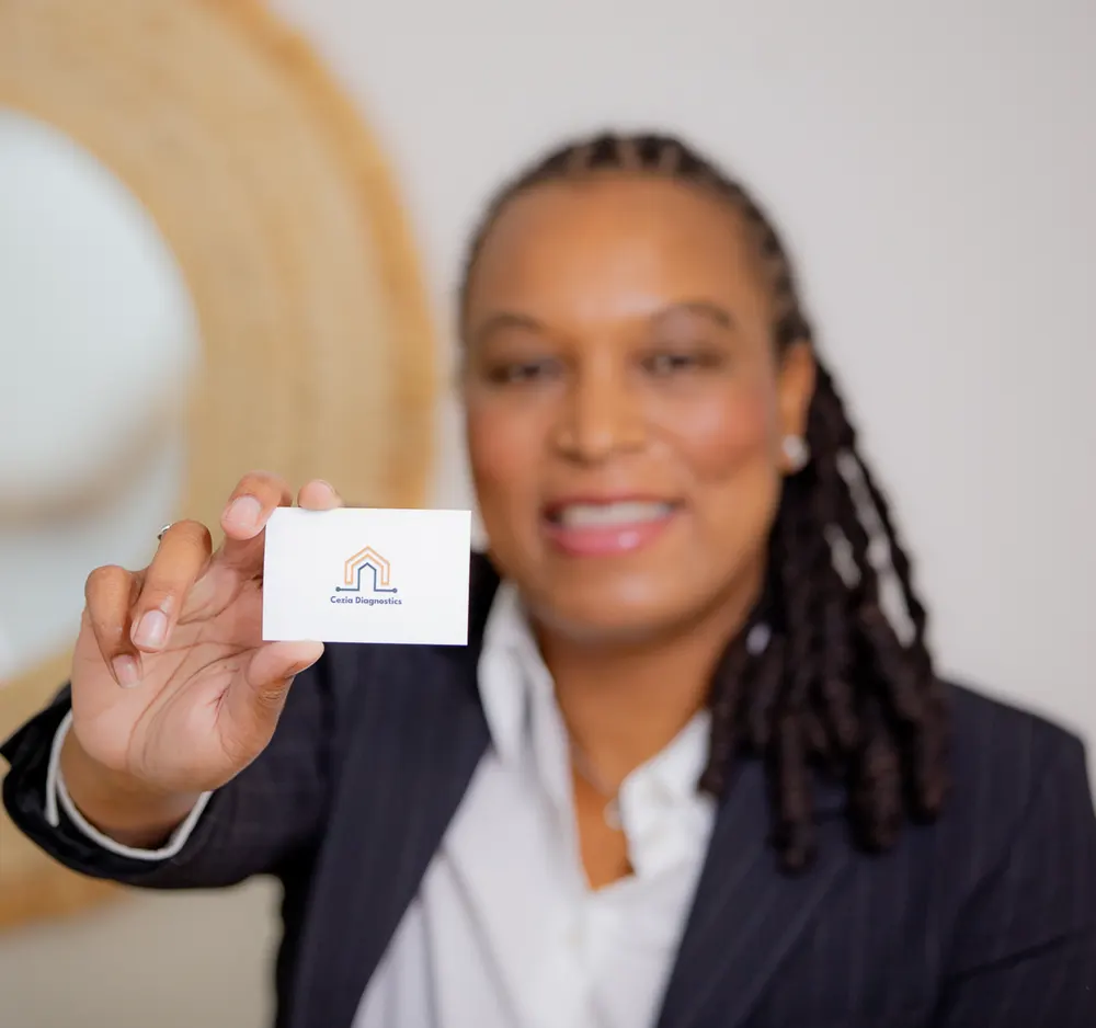 Marie-Sully Biabiany tend une carte de visite Cezia Diagnostics vers l’objectif