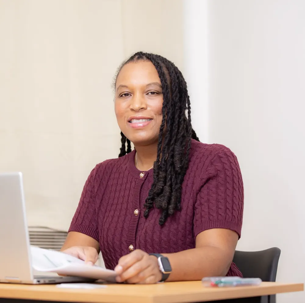 Marie-Sully Biabiany à son bureau, un dossier à la main, devant son ordinateur portable