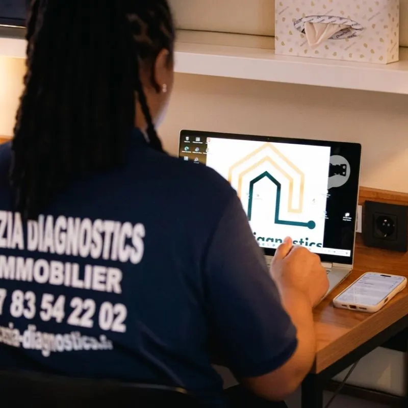 La diagnostiqueuse, de dos en polo Cezia Diagnostics, saisit un rapport sur son ordinateur portable